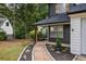 Home's inviting pathway leading to a covered entry, accentuated with black accents, offers a warm welcome at 1930 Rocky Mill Ln, Lawrenceville, GA 30044