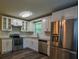 Modern kitchen features stainless steel appliances, white cabinetry, and granite countertops at 1930 Rocky Mill Ln, Lawrenceville, GA 30044