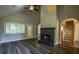 Spacious living room boasts a fireplace, large windows, updated flooring, and convenient access to the staircase at 1930 Rocky Mill Ln, Lawrenceville, GA 30044