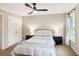 Neutral bedroom featuring large window, ceiling fan, and double door closet at 7249 Village Creek Trce, Atlanta, GA 30328