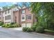 Beautiful brick townhome featuring a two-car garage and lush landscaping, enhancing its curb appeal at 7249 Village Creek Trce, Atlanta, GA 30328