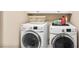 Bright laundry area with white, front-loading washer and dryer units at 7249 Village Creek Trce, Atlanta, GA 30328