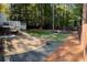 Expansive backyard with a patio, deck, lush lawn, and a charming fire pit area surrounded by trees at 1038 Ralph Ne Rd, Atlanta, GA 30324