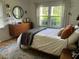 Serene bedroom with a comfortable bed, dresser, and a window overlooking lush greenery at 1038 Ralph Ne Rd, Atlanta, GA 30324