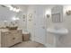 Bright bathroom with pedestal sink, storage cabinet, and decorative mirror at 1152 Ward Creek Sw Dr, Marietta, GA 30064