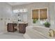 Cozy bathroom with a jacuzzi tub, vanity, and a pair of bamboo shades for privacy at 1152 Ward Creek Sw Dr, Marietta, GA 30064