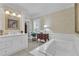 Bright bathroom with a standalone tub, tiled floors, and a white vanity with gold accents at 1152 Ward Creek Sw Dr, Marietta, GA 30064