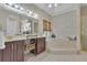 Inviting bathroom features a tiled tub and a dark wood vanity with gold accents at 1152 Ward Creek Sw Dr, Marietta, GA 30064