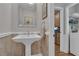 Powder room showcasing tiled walls, pedestal sink, and adjacent laundry room at 1152 Ward Creek Sw Dr, Marietta, GA 30064