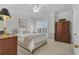 Bedroom featuring a ceiling fan, large window with shutters, and a wooden dresser at 1152 Ward Creek Sw Dr, Marietta, GA 30064