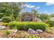 Elegant stone community sign surrounded by colorful flowers and lush greenery under a bright sky at 1152 Ward Creek Sw Dr, Marietta, GA 30064