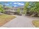 Back exterior of home showcasing a driveway and garage, set against a lush green yard and trees, ideal for Gathering living at 1152 Ward Creek Sw Dr, Marietta, GA 30064