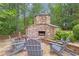Beautiful outdoor stone fireplace with firewood and comfortable seating creating a cozy and inviting outdoor space at 1152 Ward Creek Sw Dr, Marietta, GA 30064