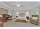 Neutral-colored main bedroom with a bed, desk, and seating area featuring a ceiling fan at 1152 Ward Creek Sw Dr, Marietta, GA 30064