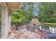 A stone patio with wrought iron railing features an outdoor fireplace and stairs leading to the garden at 1152 Ward Creek Sw Dr, Marietta, GA 30064