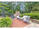 Secluded outdoor patio area with comfortable seating and a stone fireplace, ideal for enjoying the peaceful, wooded surroundings at 1152 Ward Creek Sw Dr, Marietta, GA 30064