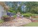 Inviting stone patio featuring an outdoor fireplace, perfect for relaxing or entertaining guests in a lush backyard setting at 1152 Ward Creek Sw Dr, Marietta, GA 30064