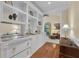 Well-lit wet bar featuring white cabinets, granite countertop, gold hardware, and seamless transition to an additional living space at 1152 Ward Creek Sw Dr, Marietta, GA 30064