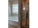 Bright bathroom featuring a soaking tub and a separate glass-enclosed shower at 11600 Winston Dr, Hampton, GA 30228