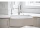 Bright kitchen features a white farmhouse sink with chrome faucet and white countertops at 4 Vale Close Ne Ct, Atlanta, GA 30324