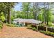 Backyard of home with patio seating area and lush landscaping and mature trees at 504 Kingswood Nw Ln, Atlanta, GA 30305