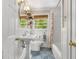 Bright bathroom featuring a pedestal sink, subway tile shower and decorative patterned floor at 504 Kingswood Nw Ln, Atlanta, GA 30305