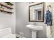 Stylish powder room featuring floating shelves, a pedestal sink, and decorative wallpaper at 504 Kingswood Nw Ln, Atlanta, GA 30305