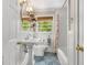 Stylish bathroom with pedestal sink, patterned tile floor, and tub with white subway tile at 504 Kingswood Nw Ln, Atlanta, GA 30305