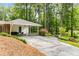 Exterior of home featuring attached carport, lush landscaping and mature trees at 504 Kingswood Nw Ln, Atlanta, GA 30305