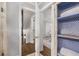 Bright hallway with wood floors leads to an upstairs, with storage space in a cabinet with a wire mesh door at 504 Kingswood Nw Ln, Atlanta, GA 30305