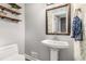 Stylish powder room features a pedestal sink, decorative mirror, and floating shelves with charming accents at 504 Kingswood Nw Ln, Atlanta, GA 30305
