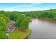 Aerial view of lakefront property with a spacious house and lush surrounding greenery at 160 Old Mill Ct, Fayetteville, GA 30214