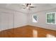 White bedroom boasts hardwood floors, ceiling fan, recessed lighting, and natural light from windows at 160 Old Mill Ct, Fayetteville, GA 30214