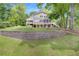 Charming three-story home with a retaining wall and a lush green lawn, set in a serene, natural environment at 160 Old Mill Ct, Fayetteville, GA 30214