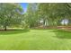 Expansive front yard with lush green grass and mature trees surrounding the property at 160 Old Mill Ct, Fayetteville, GA 30214
