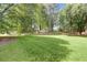 Lush green front lawn surrounded by mature trees on a sunny day at 160 Old Mill Ct, Fayetteville, GA 30214