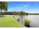 Scenic lake view with a beautiful green lawn, enhancing the natural beauty of the landscape at 160 Old Mill Ct, Fayetteville, GA 30214