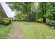 Lush backyard with mature landscaping, a stone pathway, and ample space for outdoor activities at 1690 Cedar Grove Dr, Marietta, GA 30066