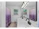 Bathroom featuring double sinks with black hardware and a purple patterned shower curtain at 1690 Cedar Grove Dr, Marietta, GA 30066