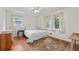 Bright bedroom with wood floors, ceiling fan, two windows, and a decorative paisley rug at 1690 Cedar Grove Dr, Marietta, GA 30066
