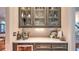 Elegant bar area featuring stylish cabinetry, marble countertops, and glass display cases for glassware at 2043 Mason Mill Rd, Decatur, GA 30033