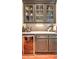 Elegant bar area featuring stylish cabinetry, marble countertops, and glass display cases for glassware at 2043 Mason Mill Rd, Decatur, GA 30033