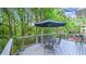 Relaxing outdoor deck area with a black umbrella, chairs and grill overlooking lush greenery at 2043 Mason Mill Rd, Decatur, GA 30033
