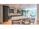 Open concept kitchen with gray cabinets, marble countertops, stainless steel appliances, island with seating, and light-filled eating area at 2043 Mason Mill Rd, Decatur, GA 30033