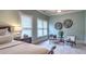 Main bedroom features a tray ceiling, fan, sitting area with comfortable chairs, and decor art at 2043 Mason Mill Rd, Decatur, GA 30033