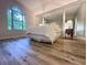 Bedroom features stylish flooring, large window, and mirrored closet at 2160 Towne Manor Nw Dr, Kennesaw, GA 30144