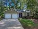 Charming single-story home with a two-car garage and blue front door framed by mature trees and green grass at 2160 Towne Manor Nw Dr, Kennesaw, GA 30144