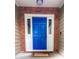 A bright blue front door is framed by white trim and red brick, adding a pop of color to the entrance at 2160 Towne Manor Nw Dr, Kennesaw, GA 30144