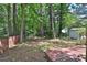 Backyard view, featuring a small, fenced yard, trees, and a detached storage shed at 4120 Buckley Woods Dr, Norcross, GA 30093