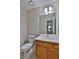 Well-lit half bathroom featuring a toilet, mirror, and cabinet sink at 4120 Buckley Woods Dr, Norcross, GA 30093